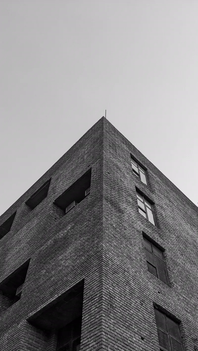 Quina de um edifício de tijolos vista de baixo contra o céu.