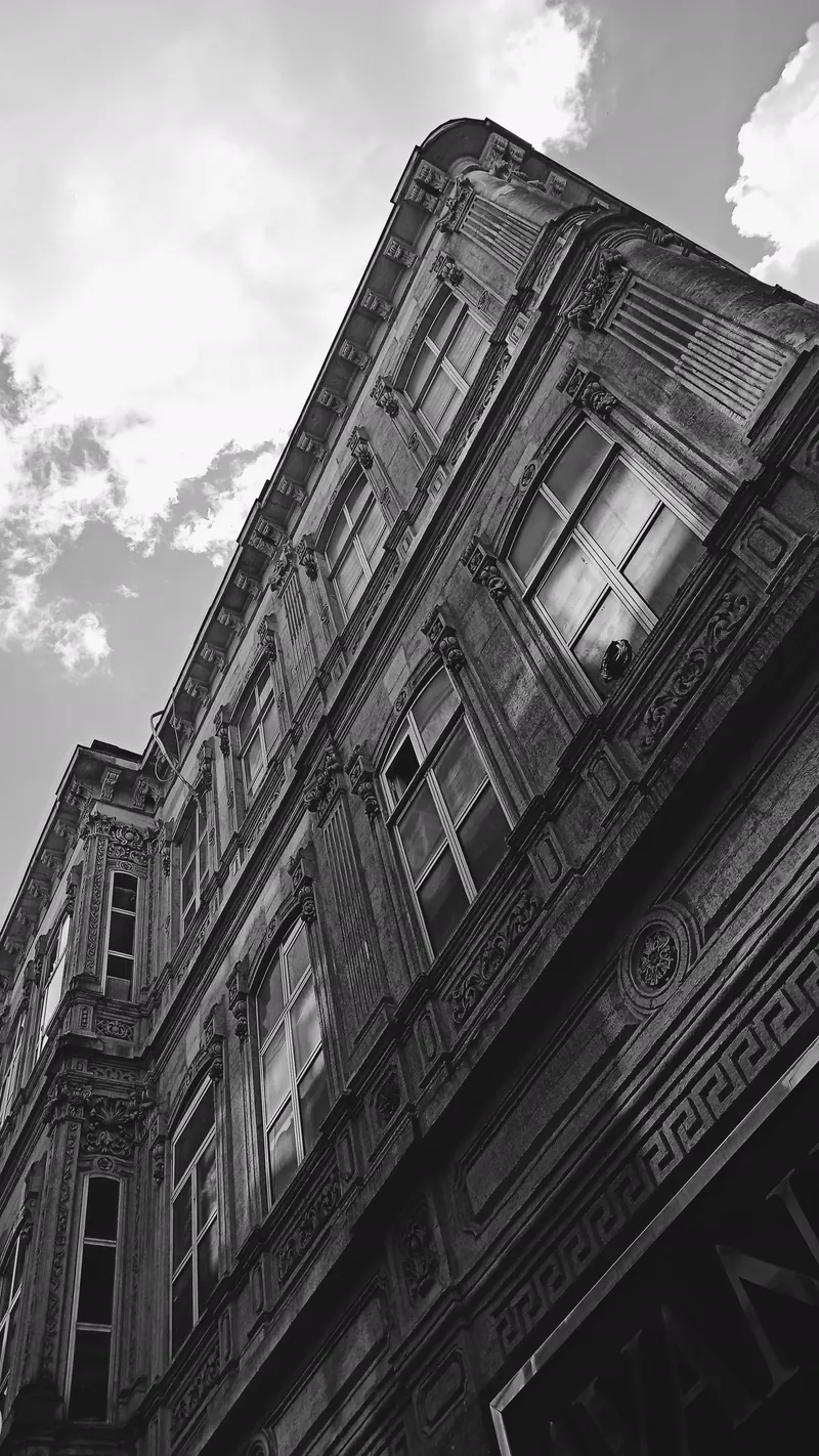Fachada histórica ornamentada vista em perspectiva diagonal.